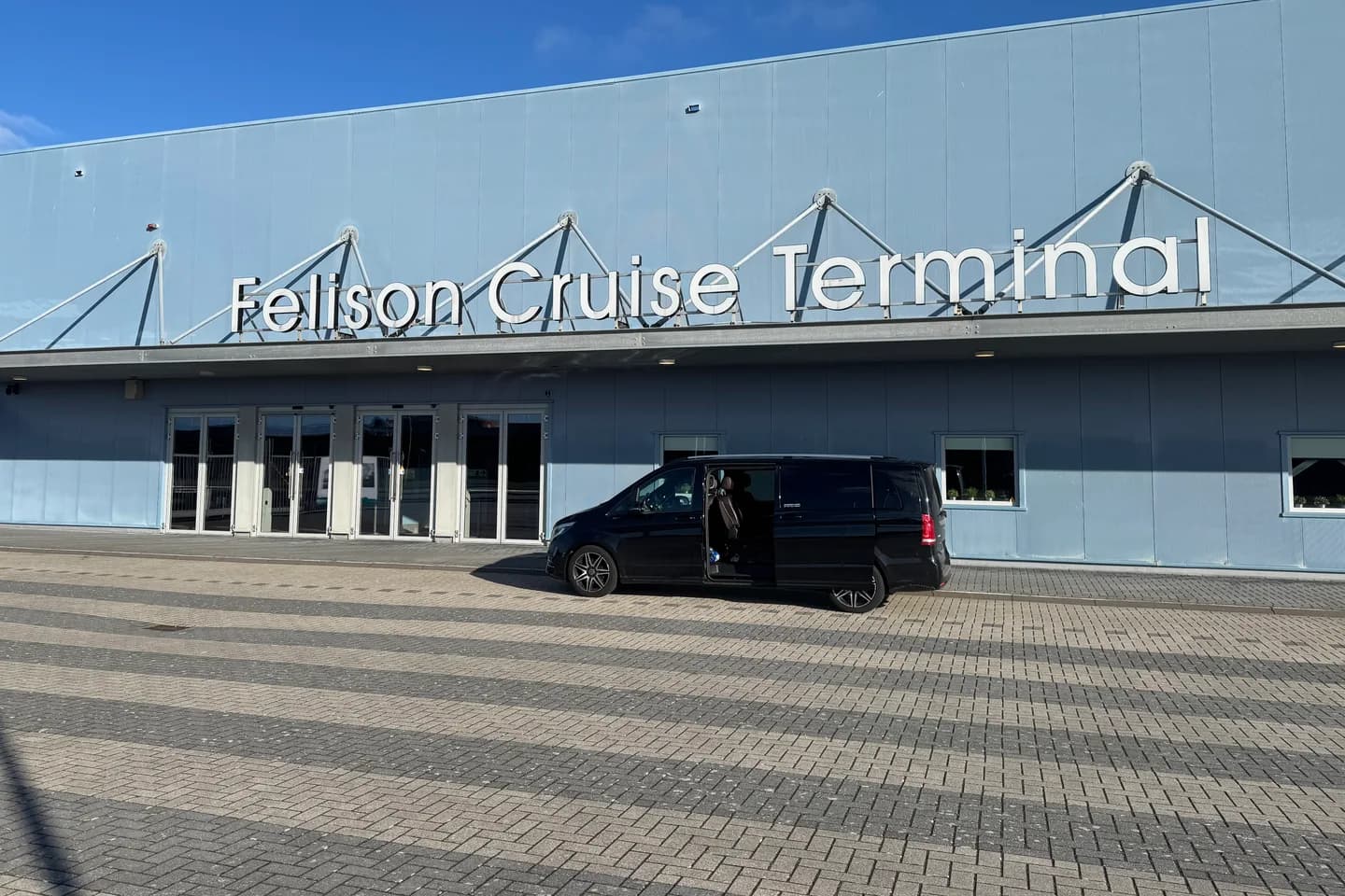 Zwarte Mercedes V-Klasse van Taxi Centrale Heemskerk met geopende schuifdeur voor de Felison Cruise Terminal aan de Monnickendamkade in IJmuiden