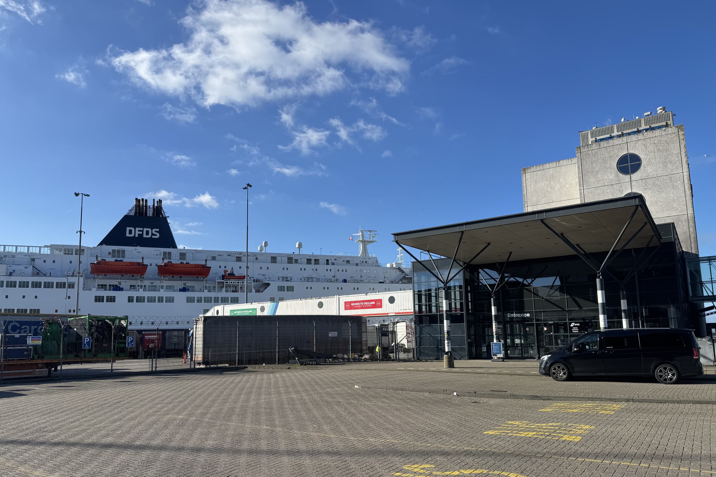 Zwarte Mercedes V-Class van Taxi Centrale Heemskerk bij de ingang van de Felison Terminal in IJmuiden, met de veerboot van DFDS aan de kade